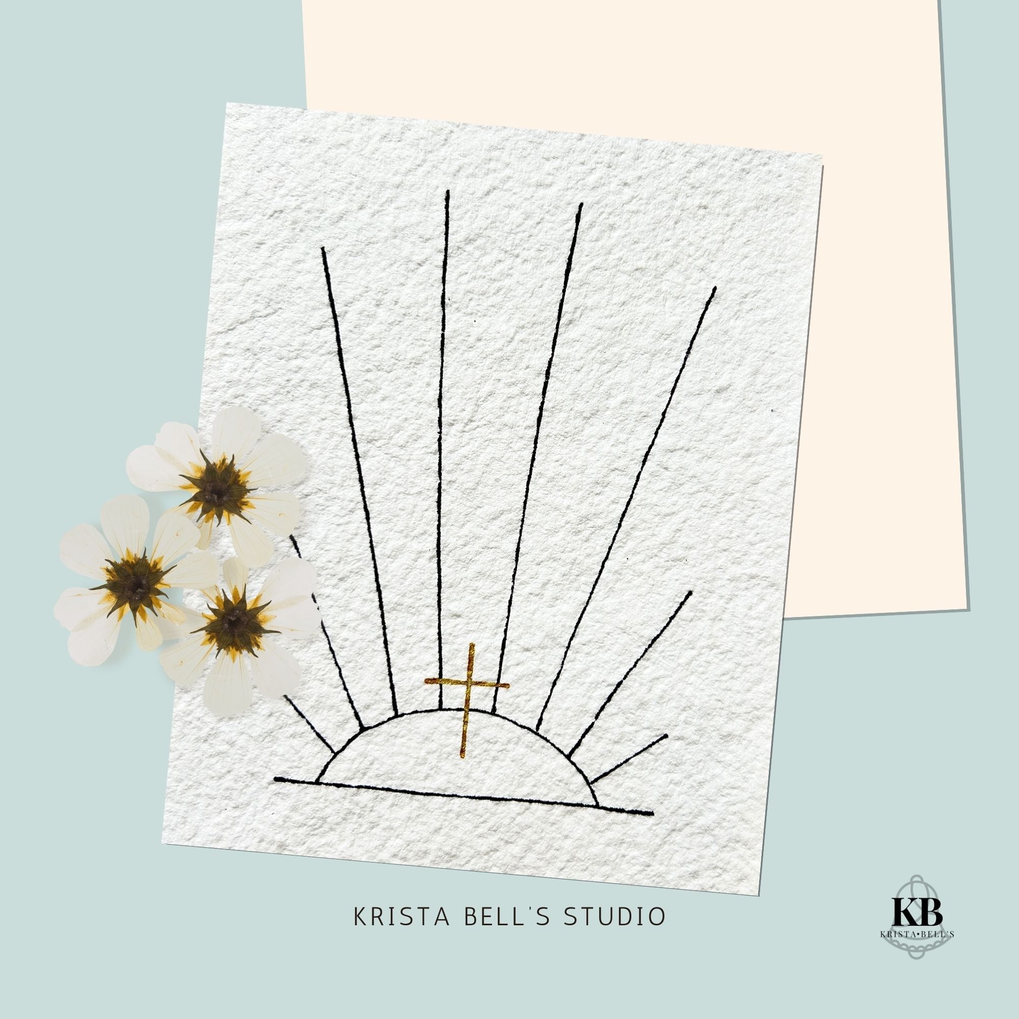 Artistic depiction of a sun with flowers on a textured paper background, featuring the brand 'Krista Bell's Studio'.