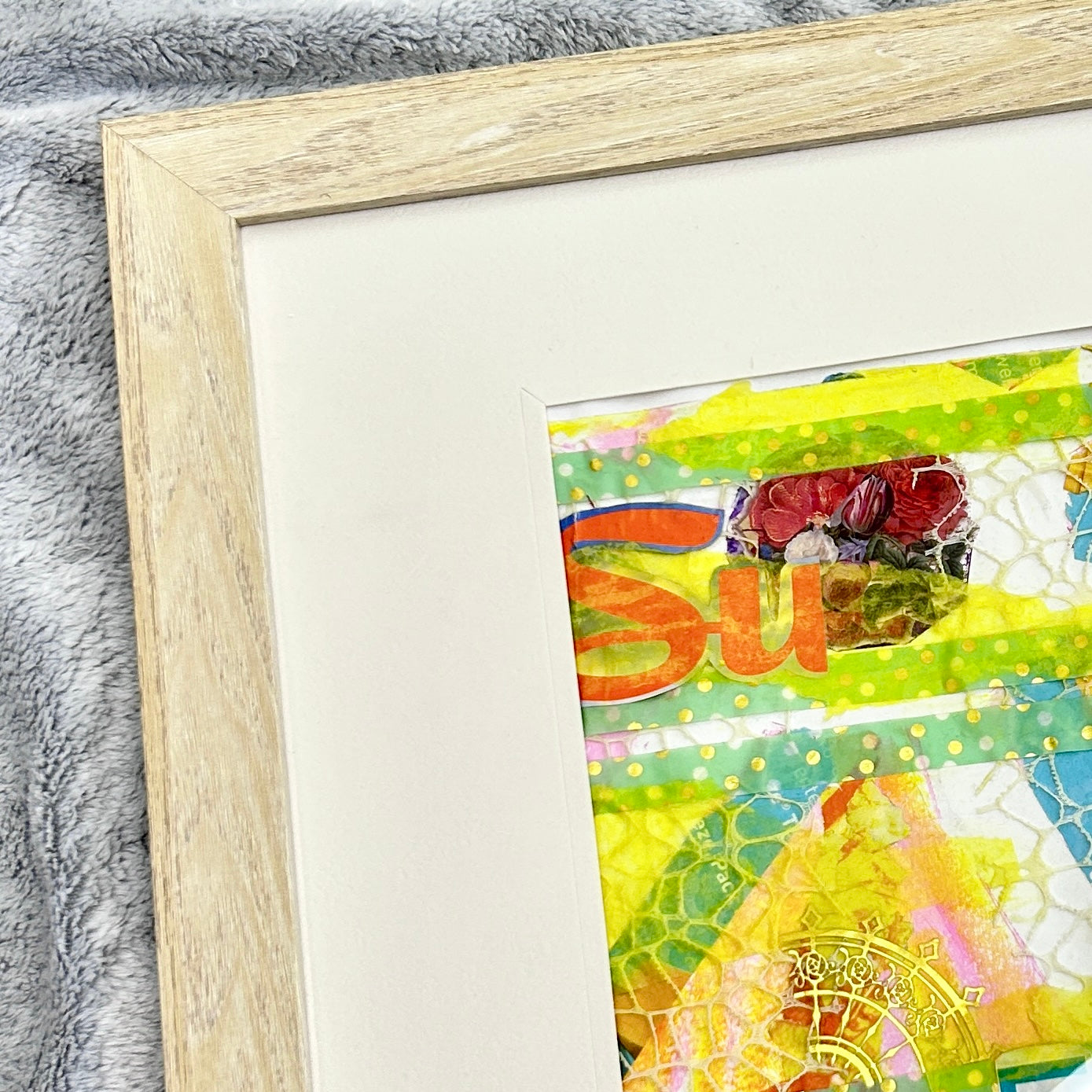 Colorful artwork with text inside a wooden frame on a textured surface. A yellow and teal mixed media collage reflecting on the joy found in life when you thoughts, actions, and emotions align with your values. 