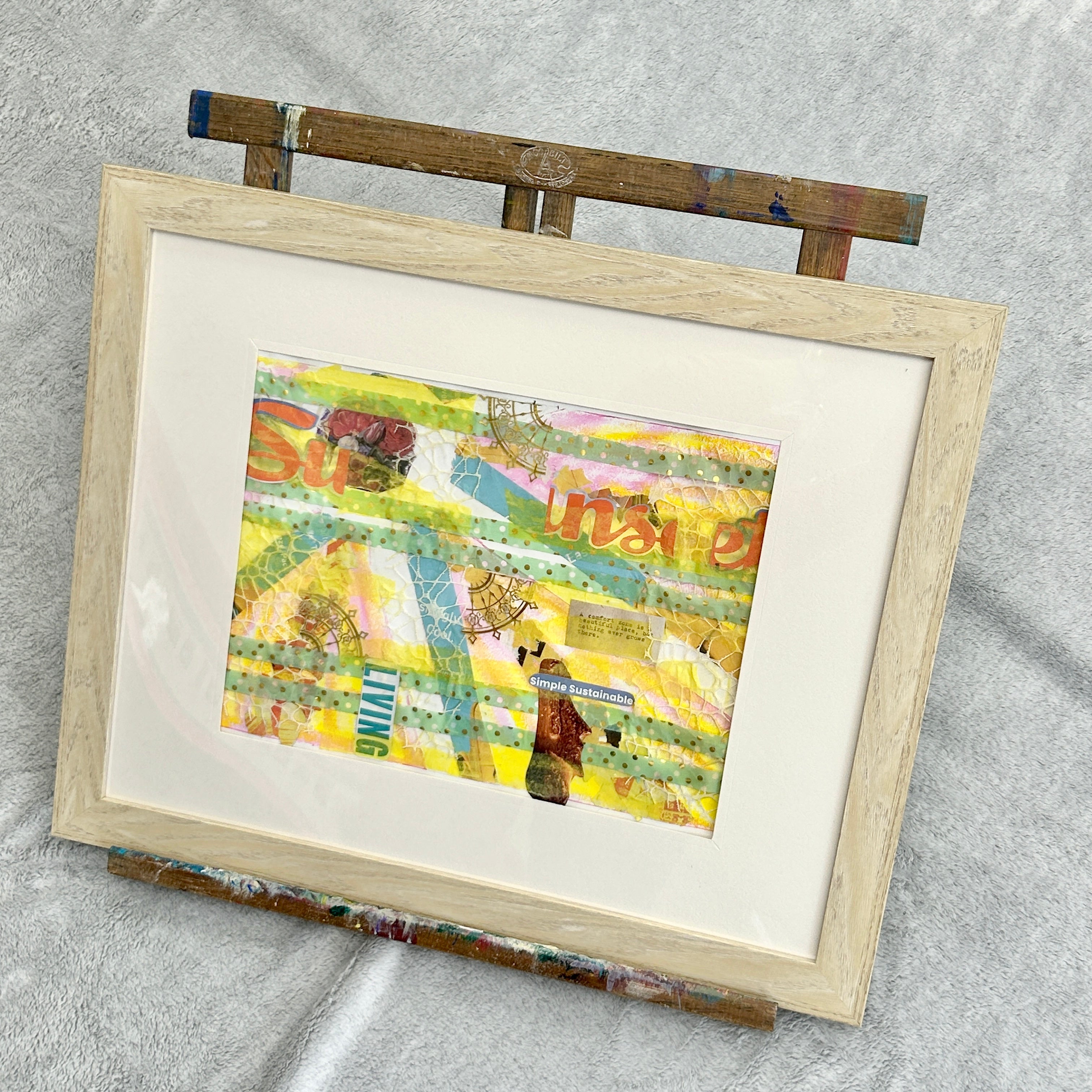 Framed artwork with a colorful abstract design on a gray background. A yellow and teal mixed media collage reflecting on the joy found in life when you thoughts, actions, and emotions align with your values. 