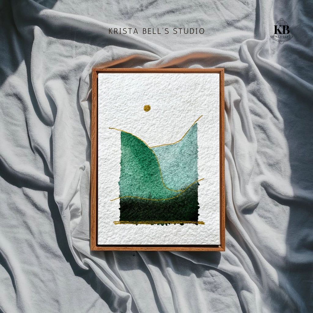 Framed artwork with green abstract design on textured fabric, featuring 'Krista Bell's Studio' branding.