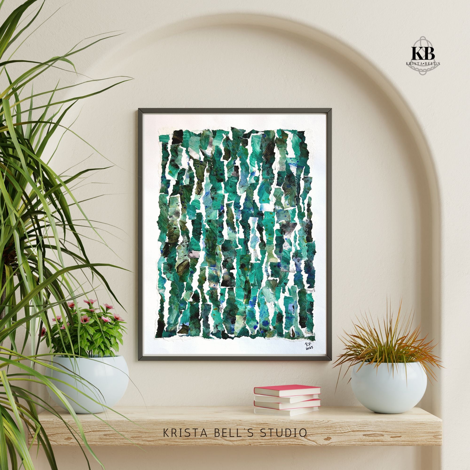 Framed abstract art print with green and blue patterns on a wall with plants and books below.