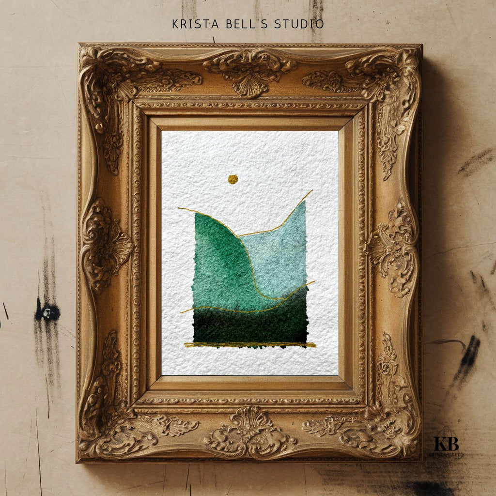 Decorative gold frame with a piece of simple modern watercolor landscape art on a textured beige wall.
