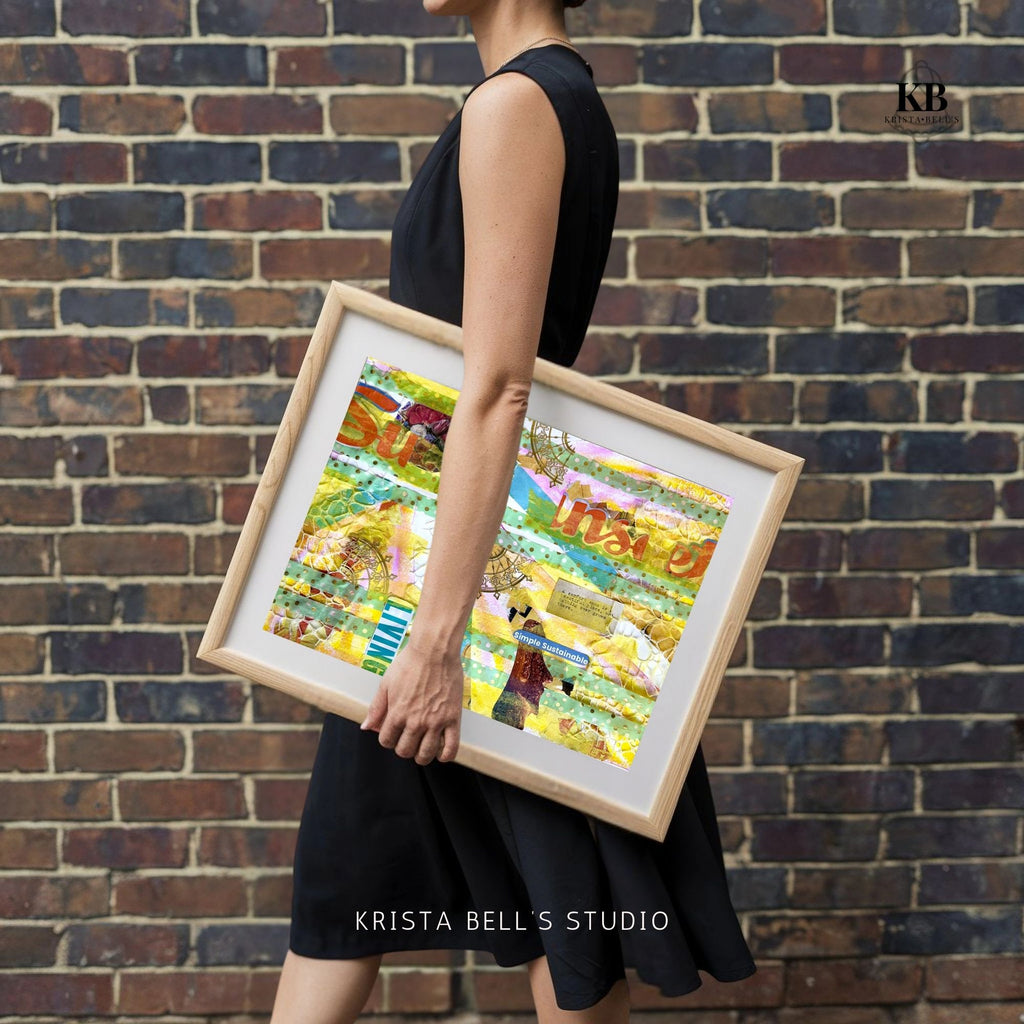 Person holding a framed artwork against a brick wall, with 'Krista Bell's Studio' branding. A yellow and teal mixed media collage reflecting on the joy found in life when you thoughts, actions, and emotions align with your values. 
