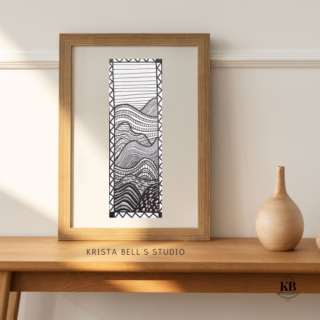 Framed black and white abstract art print on a wooden shelf with 'Krista Bell's Studio' branding.
