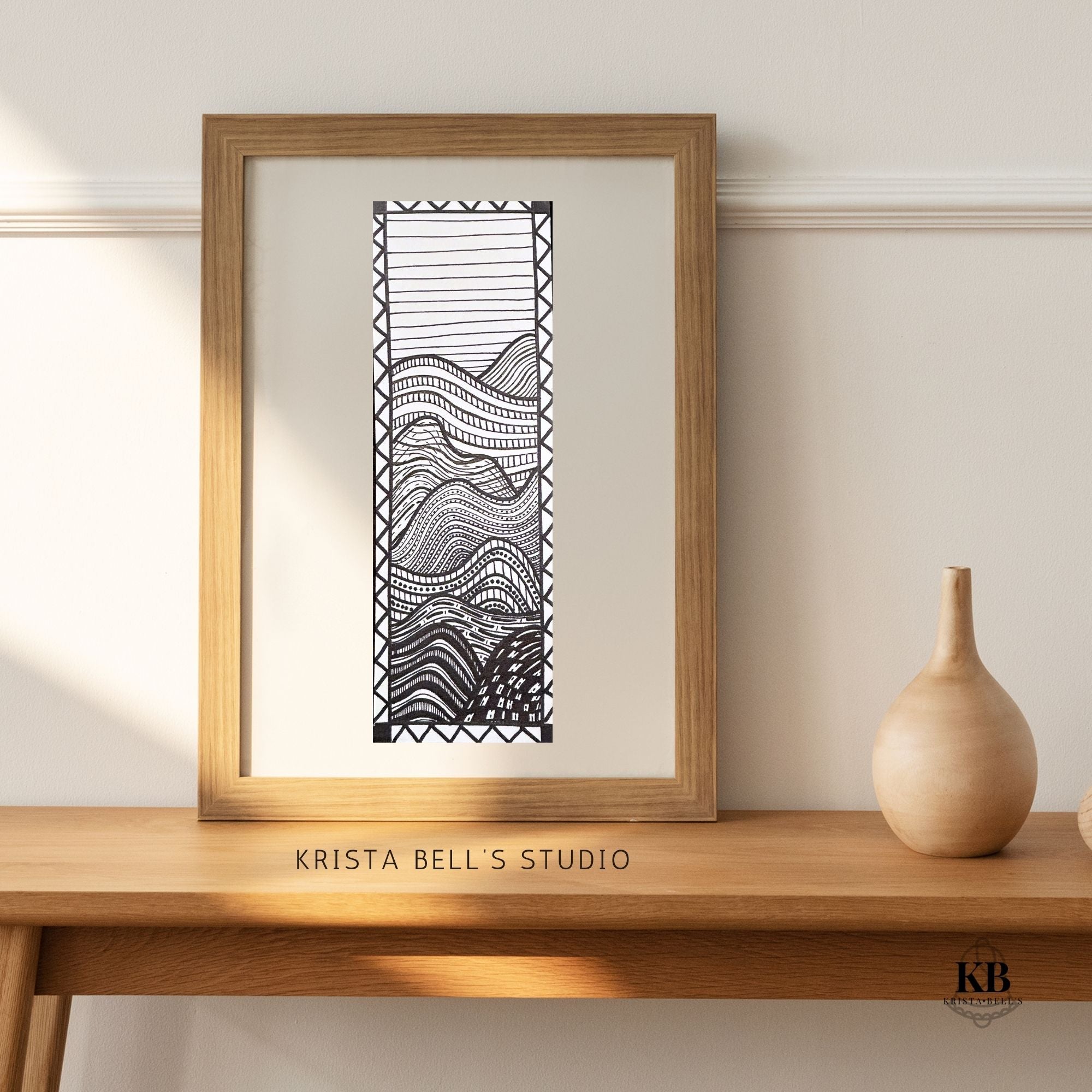 Framed black and white abstract art print on a wooden shelf with 'Krista Bell's Studio' branding.