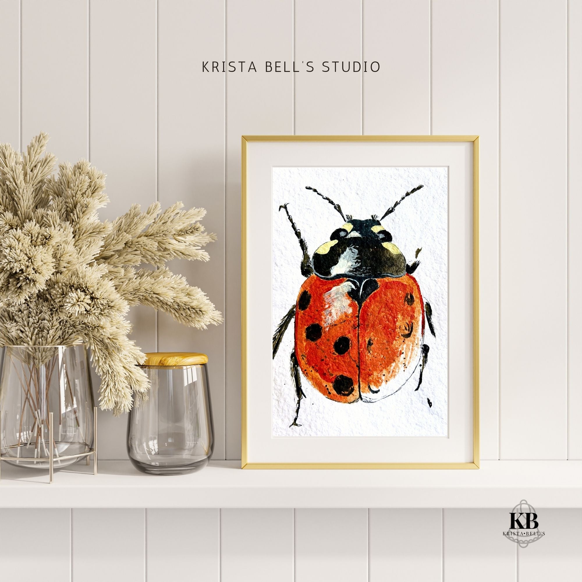 Framed artwork of a ladybug on a white wall with decorative elements.