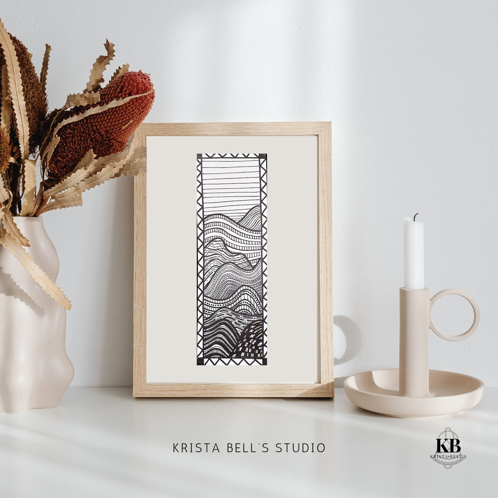 Framed black and white abstract artwork on a white surface with decorative elements.