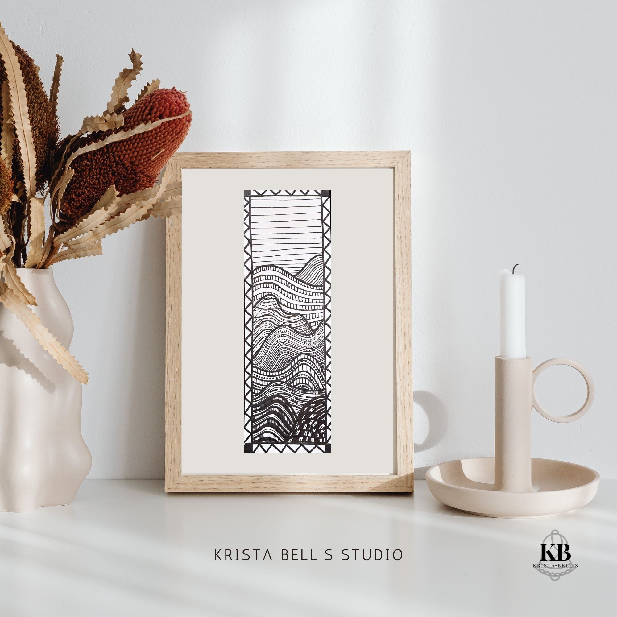 Framed black and white abstract artwork on a white surface with decorative elements.