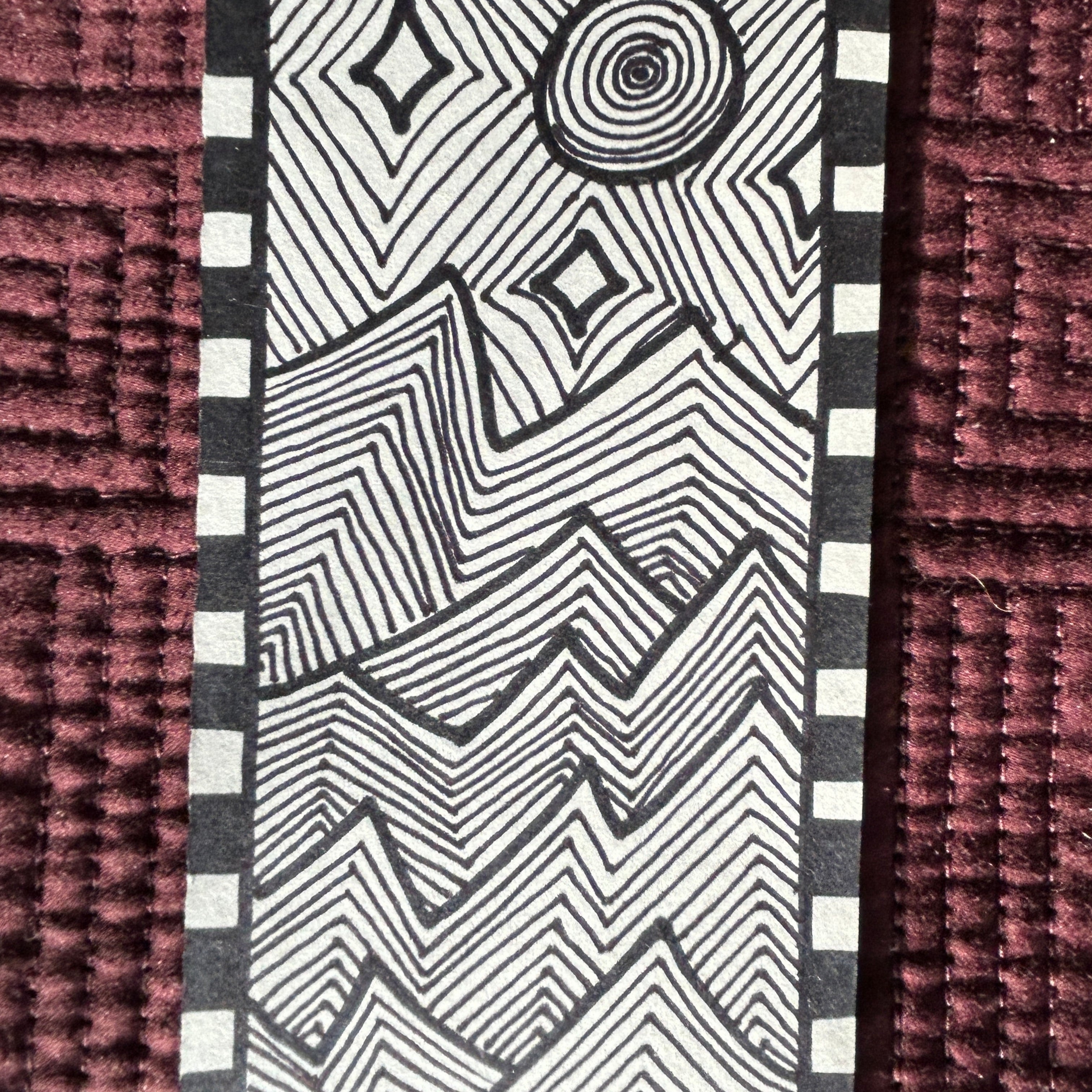 Black and white geometric pattern on a textured muted purple quilt surface. black and white modern abstract line art patterned of jagged mountains in the moon light and stars.
