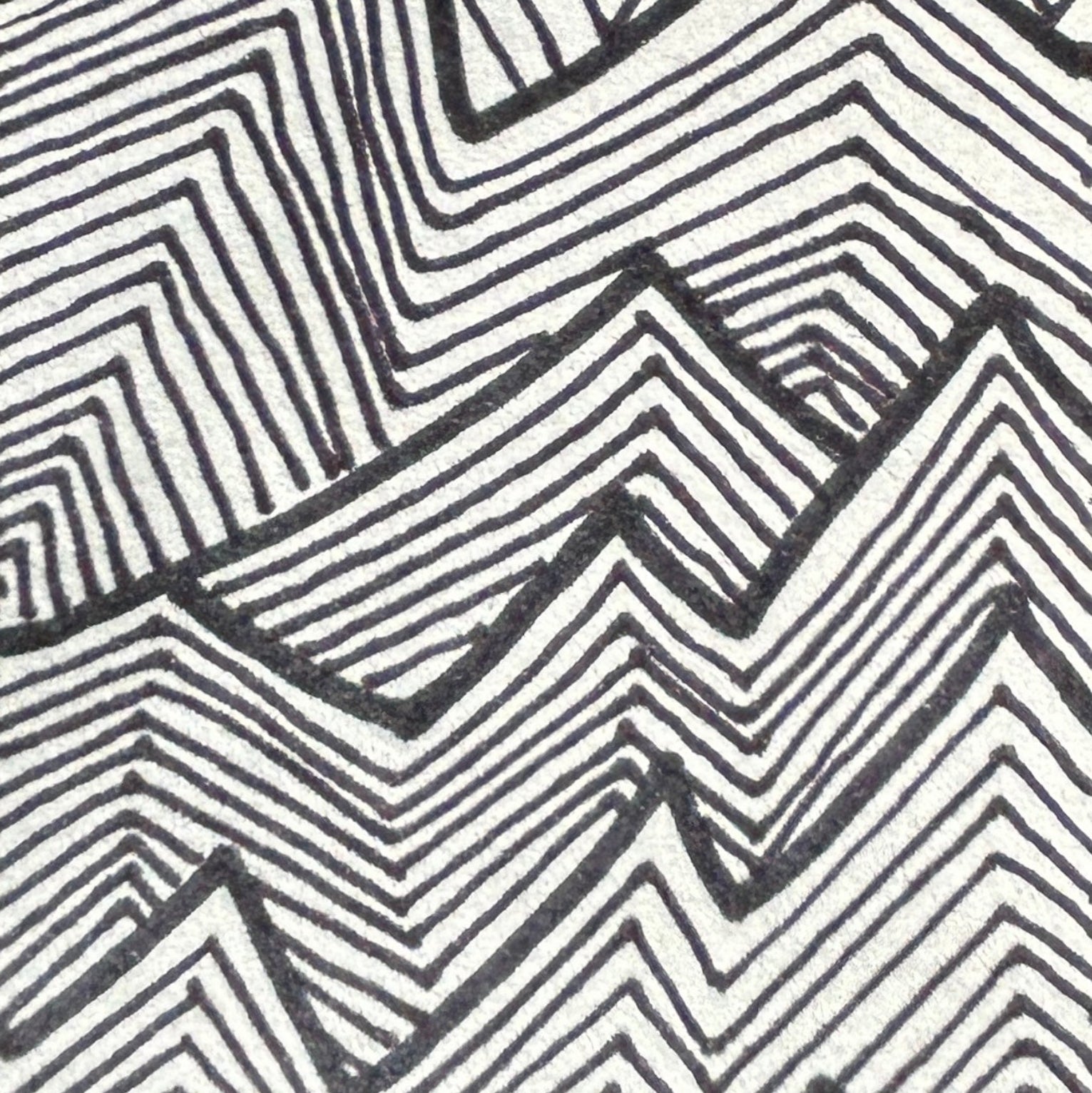 Close up of a black ink drawing, geometric zig zag pattern on a white background.