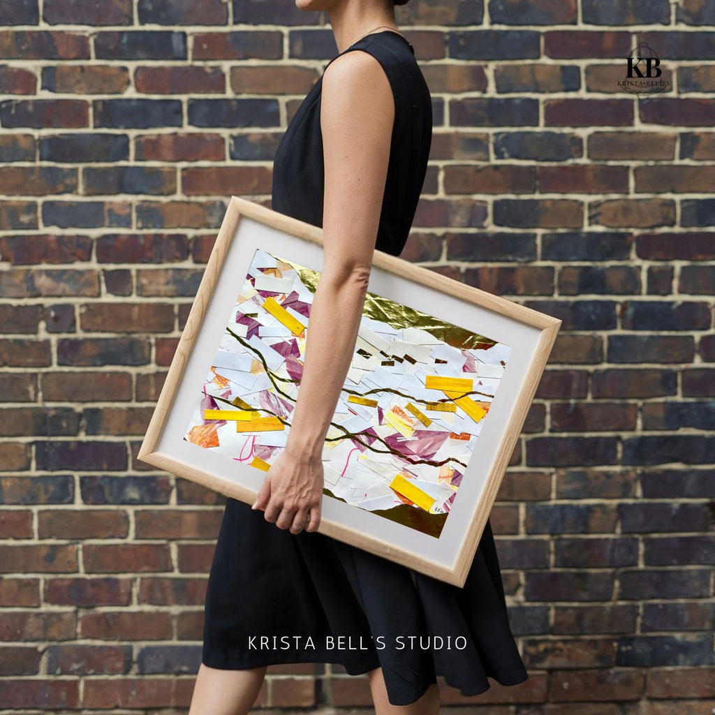Person holding a framed abstract art piece against a brick wall, with 'Krista Bell's Studio' branding.  A calm abstract collage with meandering golden lines. Listen to the gentle guiding of the Lord. His calling is the gold line running through our lives.
