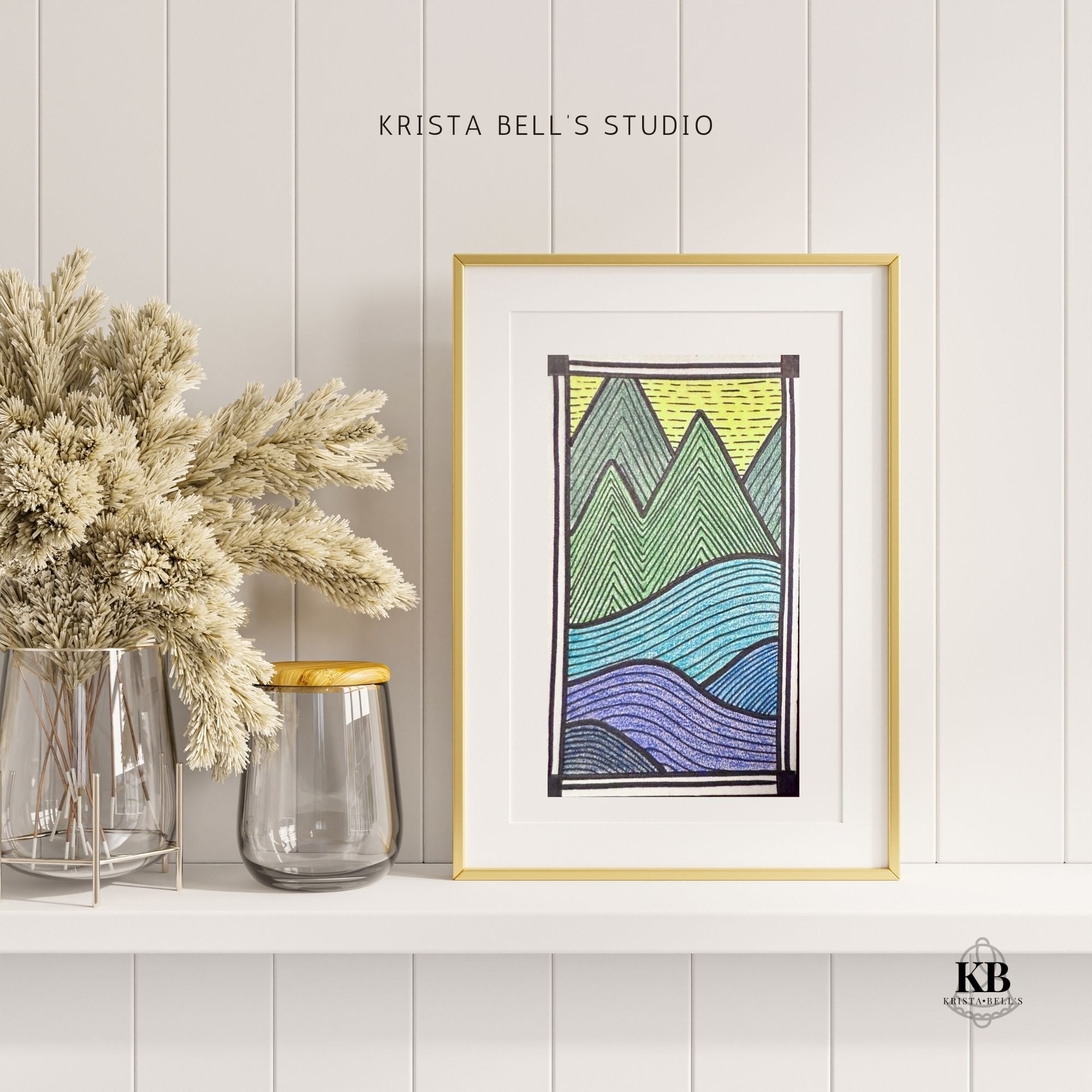 Framed abstract art print with mountains on a white wall, featuring 'Krista Bell's Studio' branding.