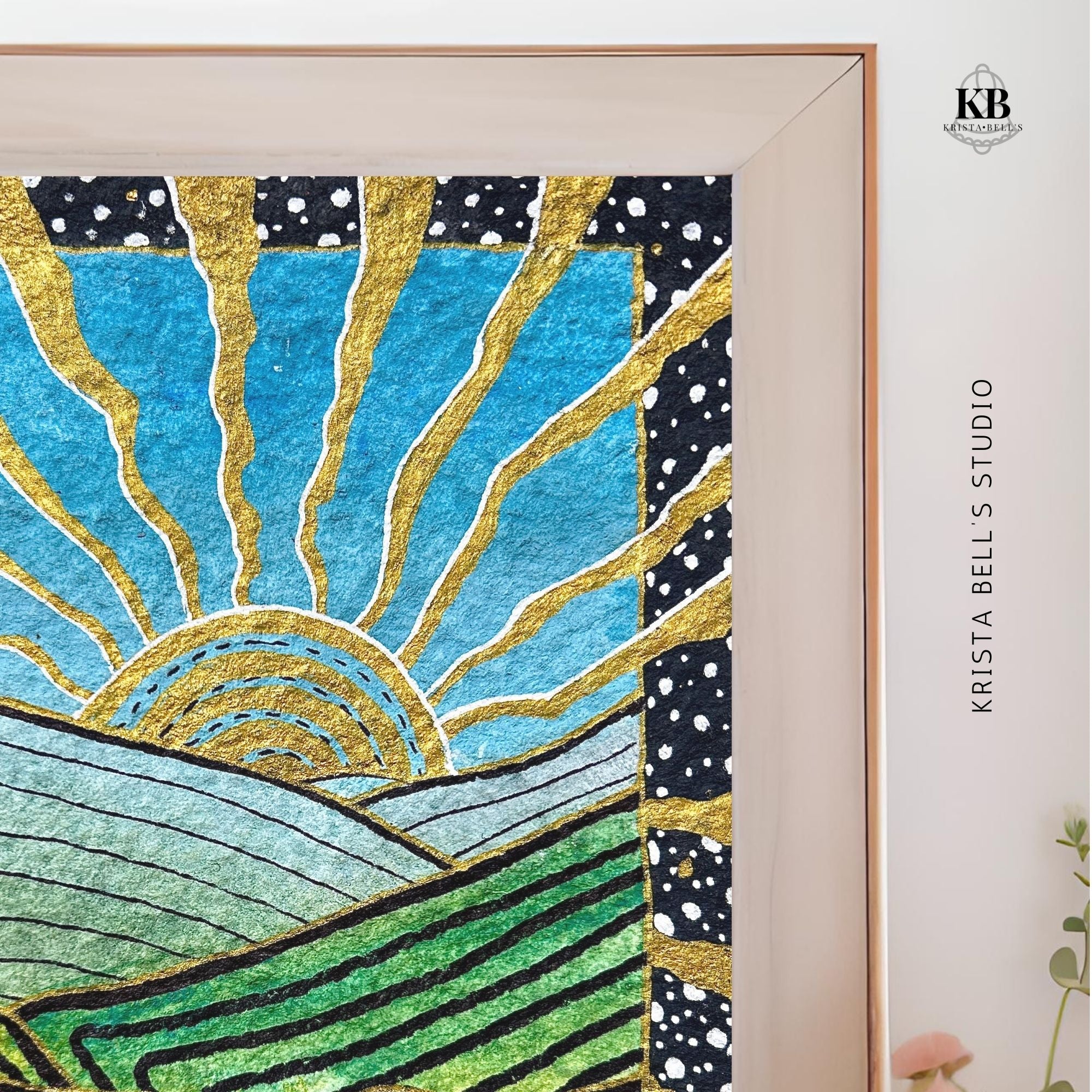 Framed artwork with abstract design of a sun and landscape, featuring gold, blue, and green colors.