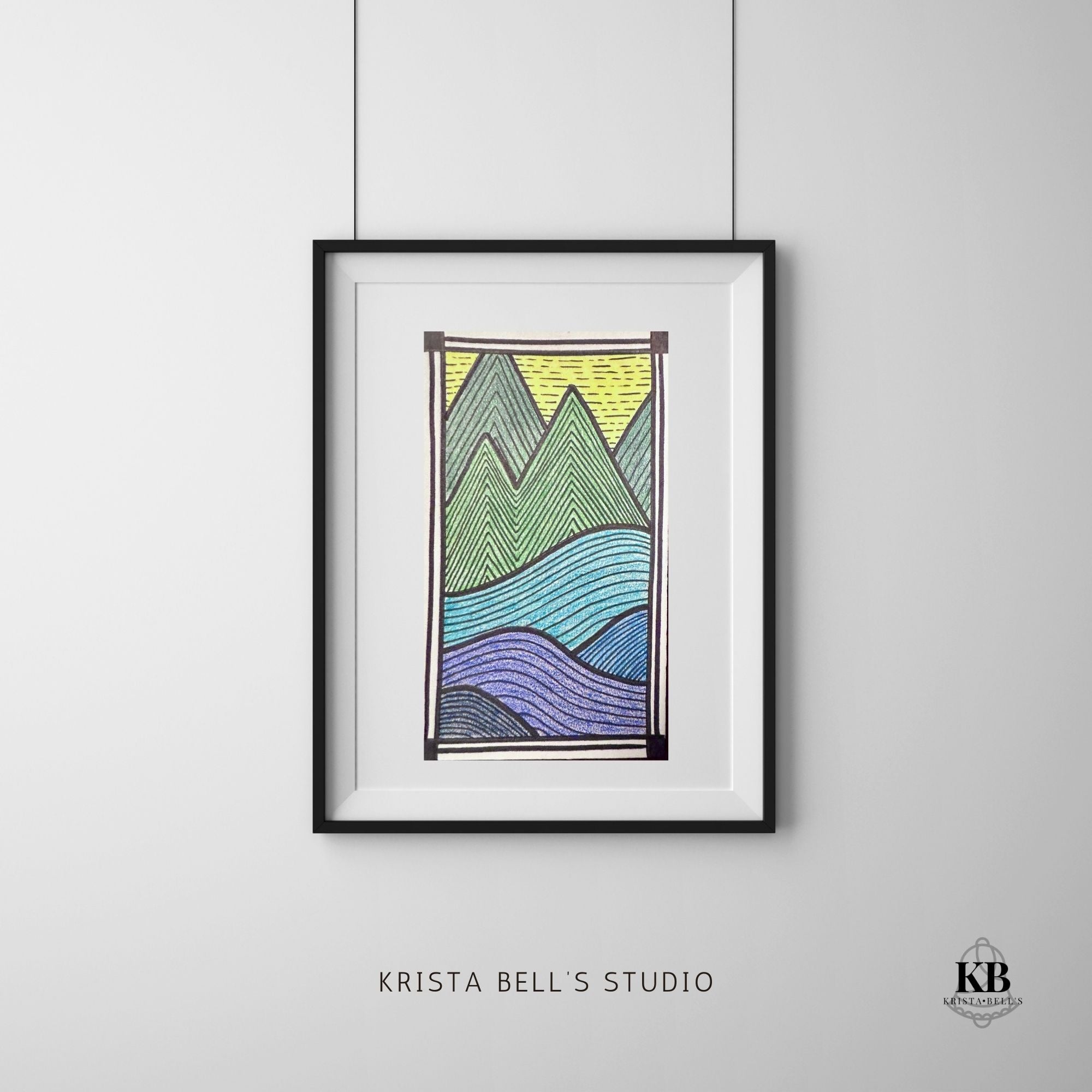 Framed artwork of mountains on a gray wall with 'Krista Bell's Studio' branding.