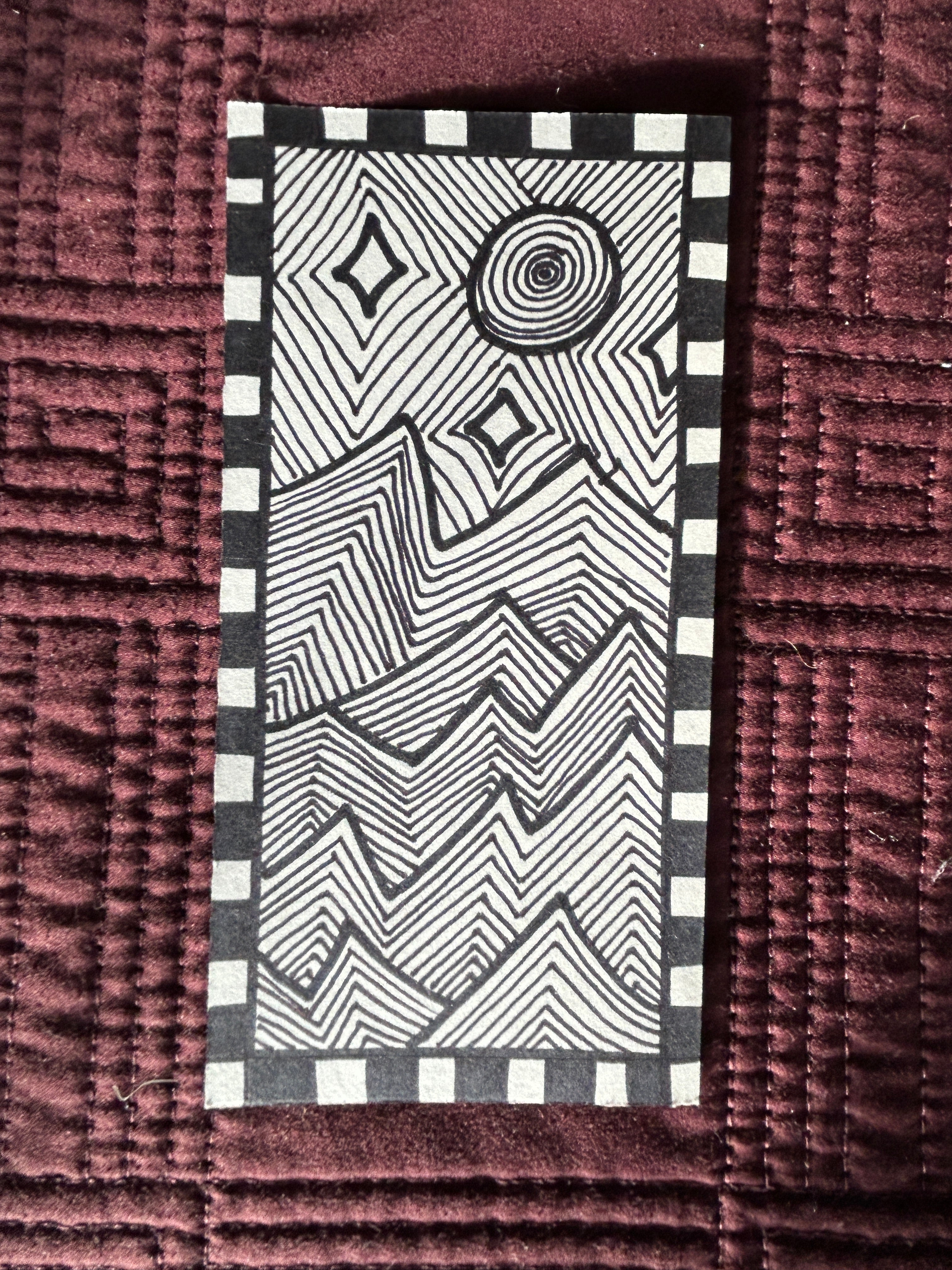 Black and white geometric pattern on a textured muted purple quilt surface. black and white modern abstract line art patterned of jagged mountains in the moon light and stars.