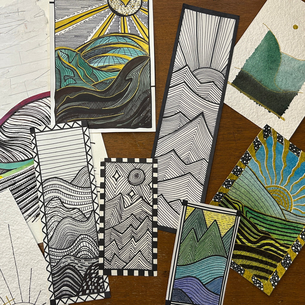 Collection of artistic bookmarks with various designs on a wooden surface