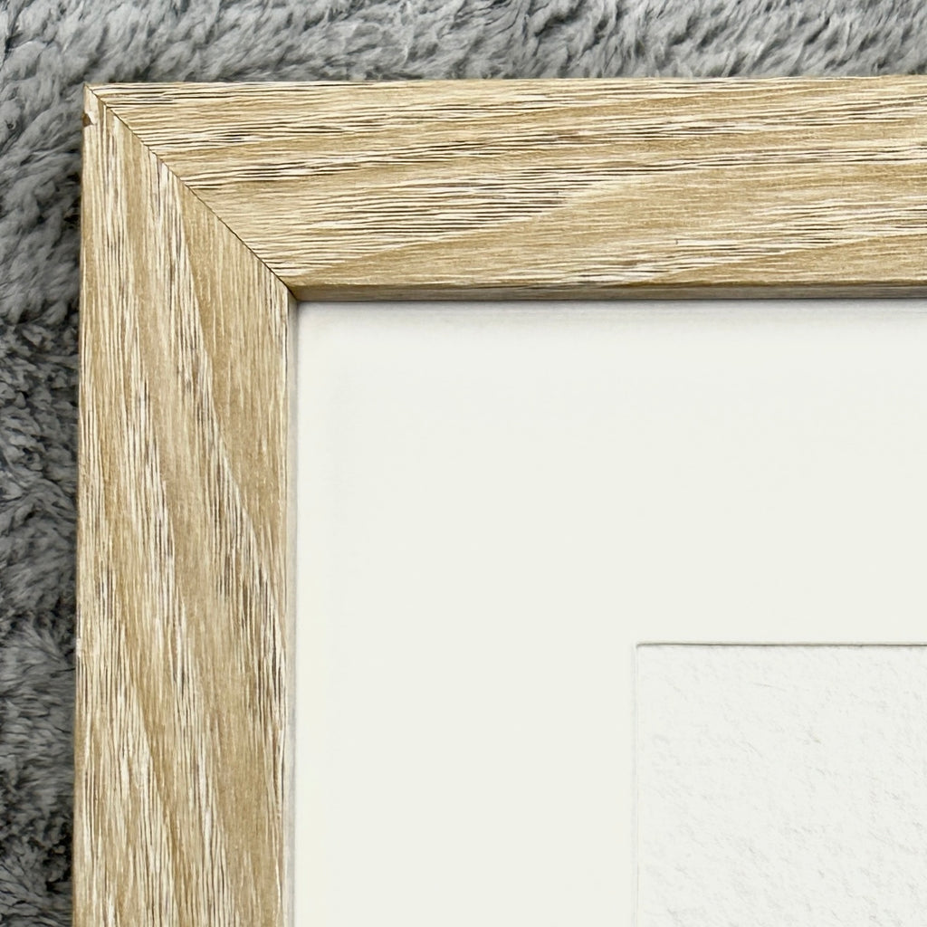 Close-up of a wooden picture frame corner on a textured surface