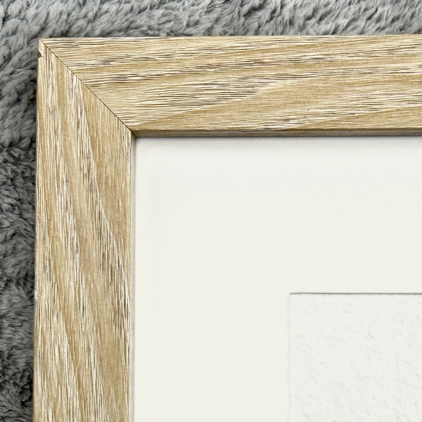 Close-up of a wooden picture frame corner on a textured surface