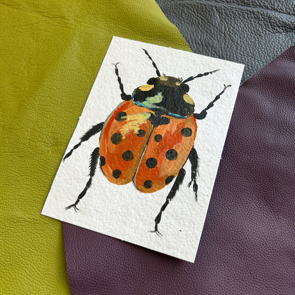 Painting of a a strong steady ladybug on a textured surface
