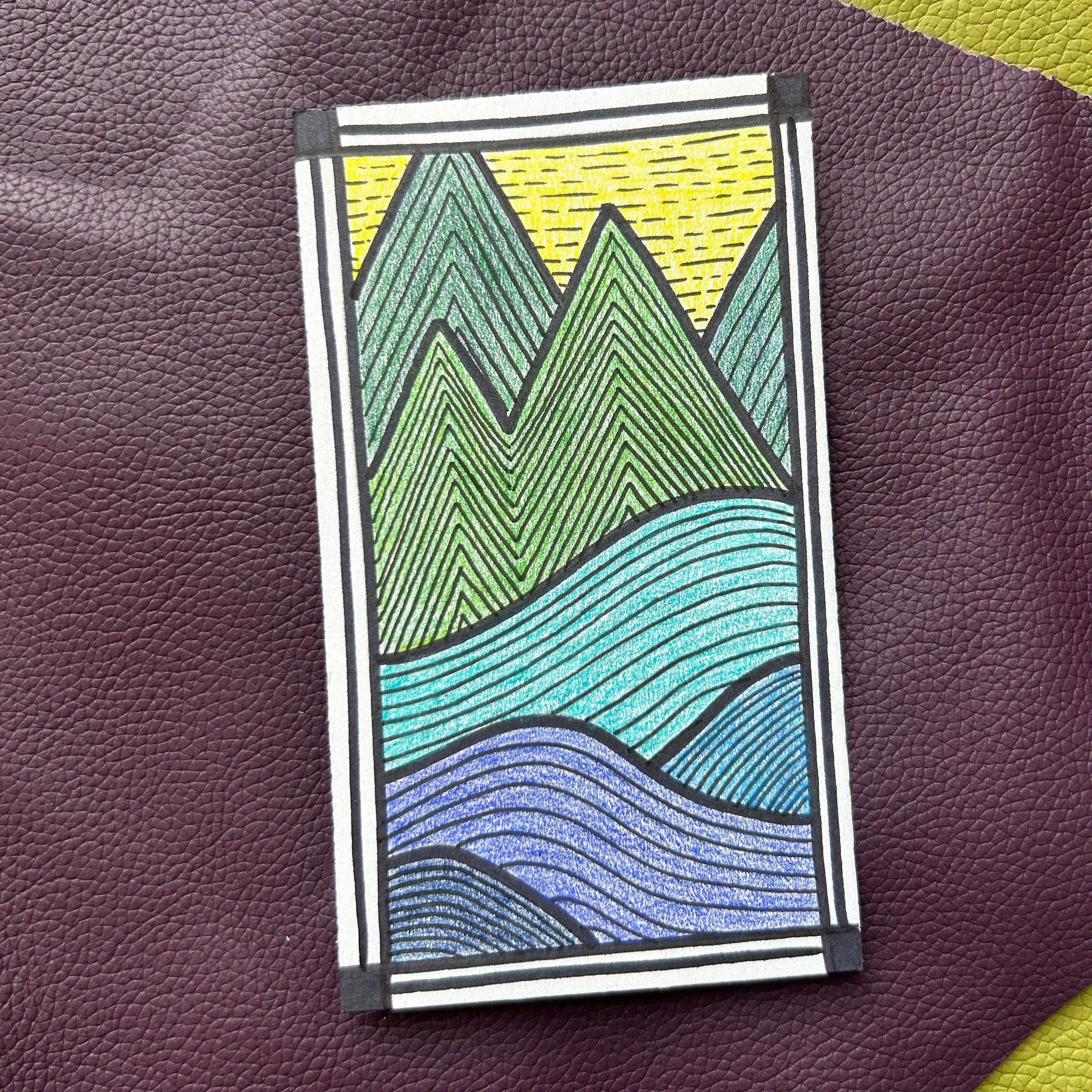 Card with mountain and wave design on a textured surface