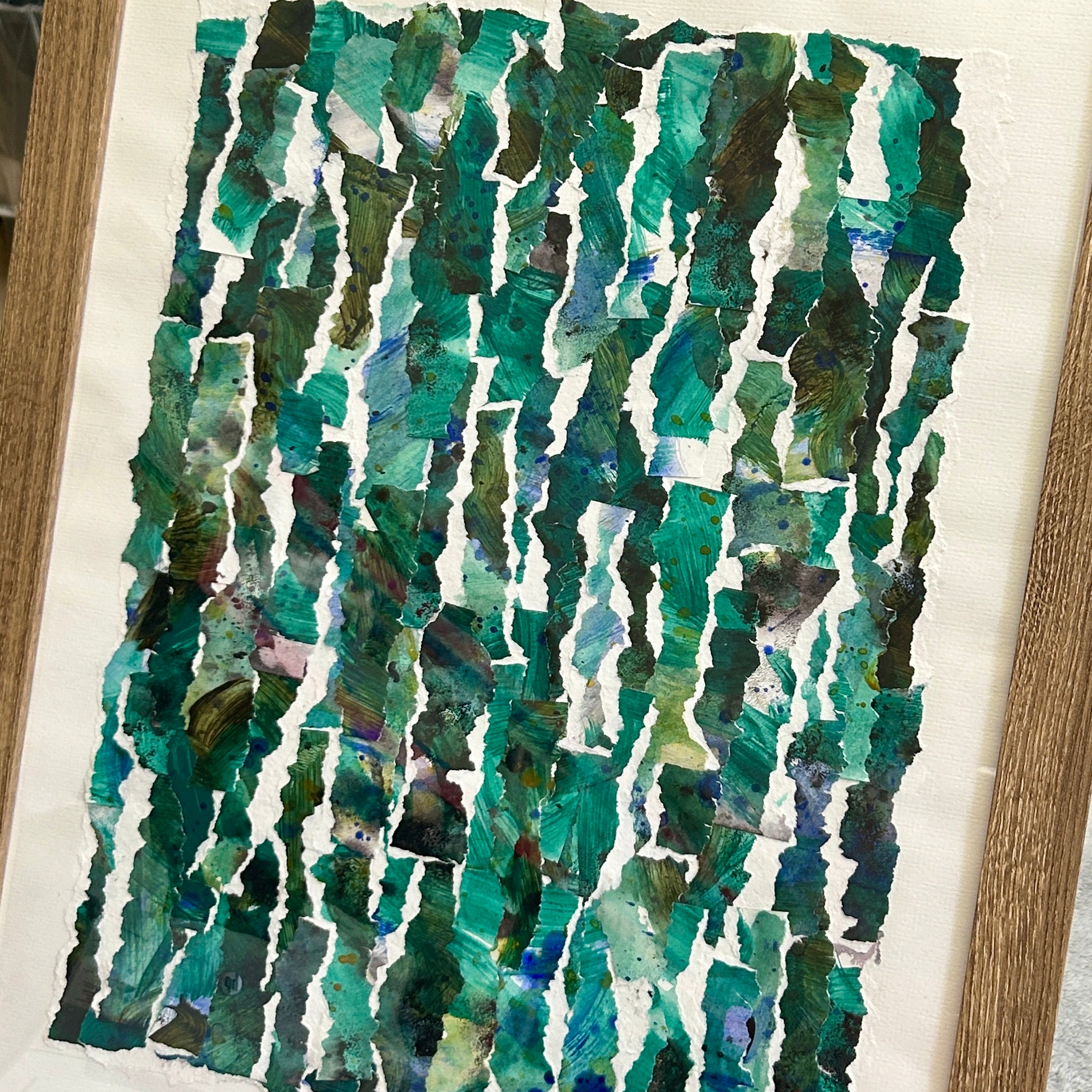 Framed Abstract art piece with green and blue patterns on a white background