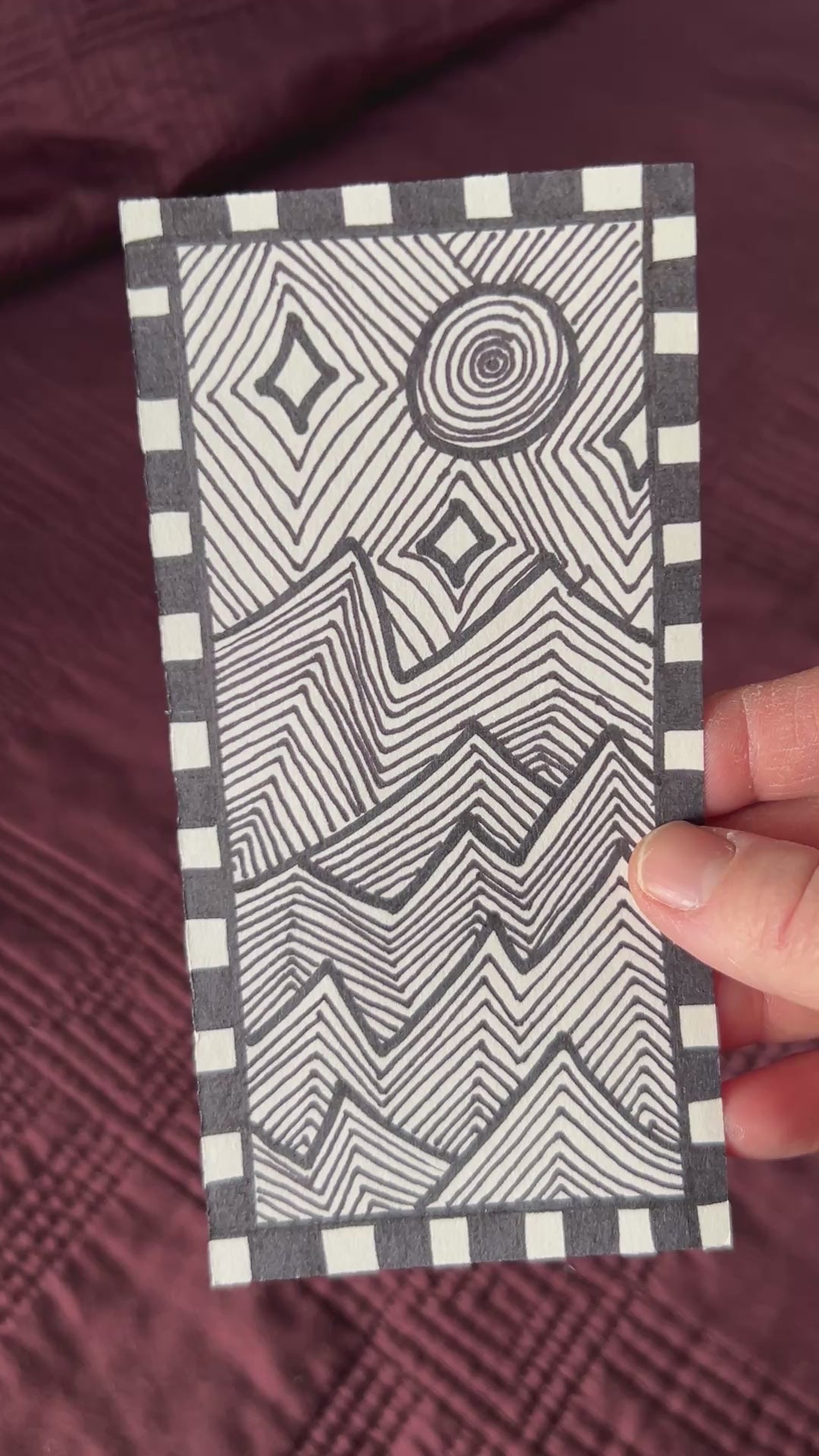 Short video showing the original artwork for sale. A black and white modern abstract line art patterned of jagged mountains in the moon light and stars.