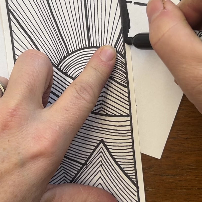 Short video of the artist adding a black border to the art work "Line After Line" with permanent black ink.
