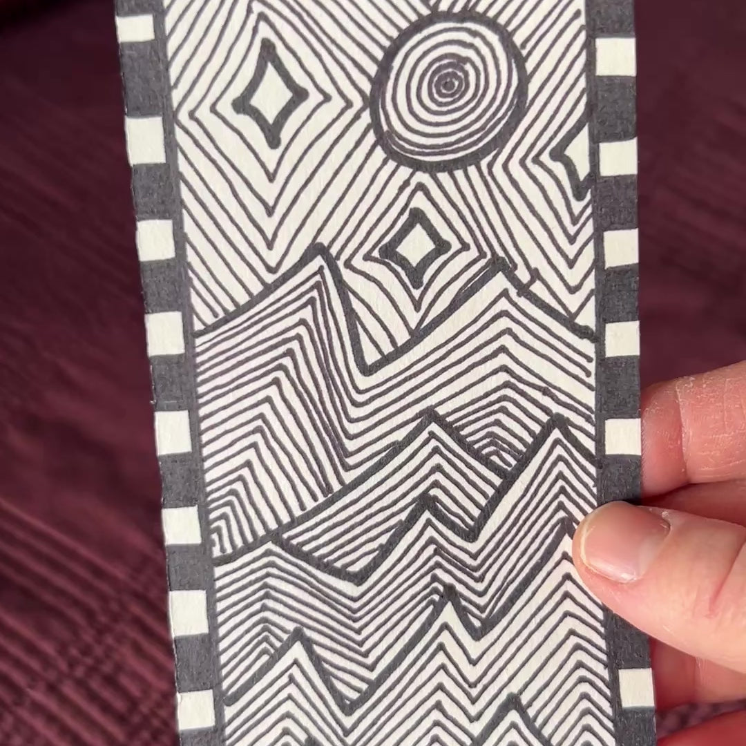 Short video showing the original artwork for sale. A black and white modern abstract line art patterned of jagged mountains in the moon light and stars.